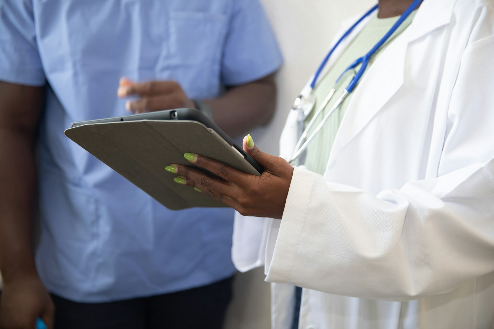 Doctor using a tablet with a patient - the daily moment where AI tools meet HIPAA risk