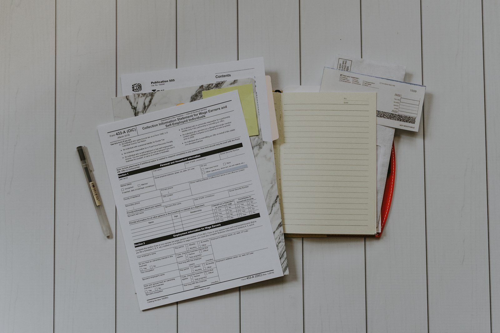 Two business proposals side by side on a desk with laptop showing comparison spreadsheet