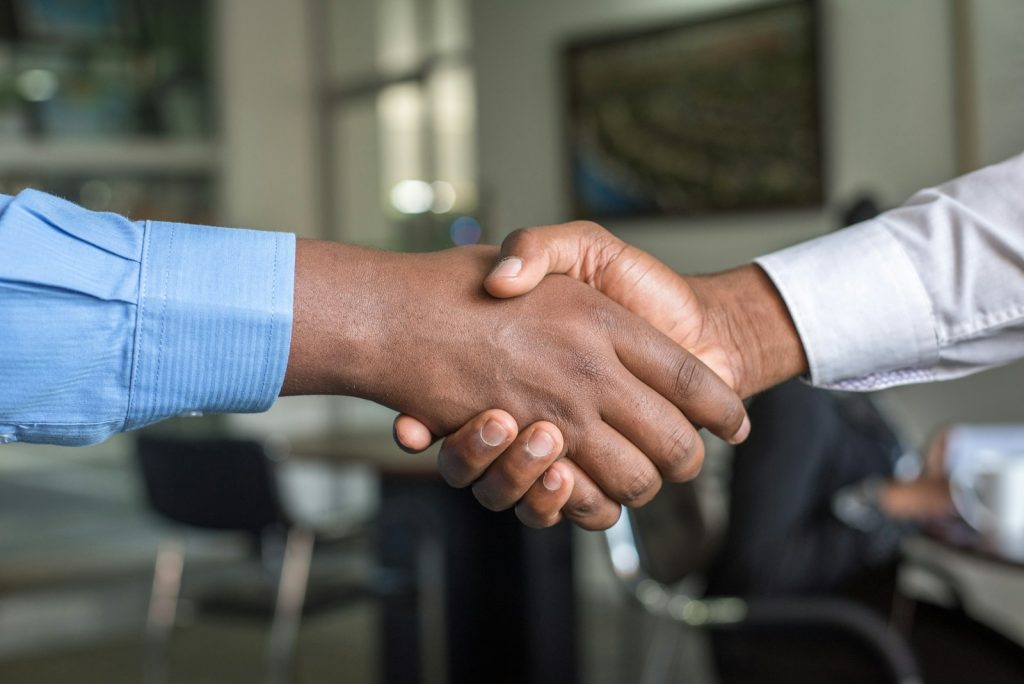 Two professionals shaking hands in modern office