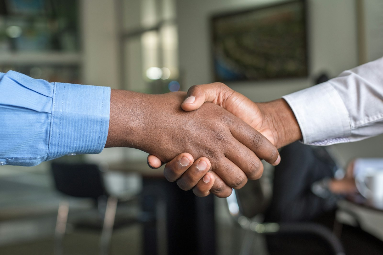Two professionals shaking hands in modern office